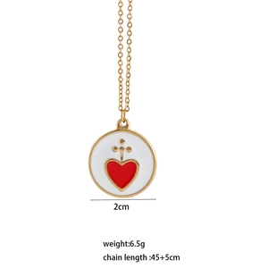 Macro d'un pendentif en acier doré de 2cm avec émail blanc et cœur rouge vif