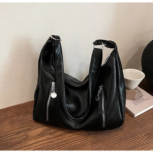 Close-up of black retro tote bag showing lychee grain texture and zipper detail