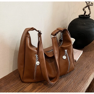 Close-up of caramel vintage tote bag with pebble leather texture and metal zipper details