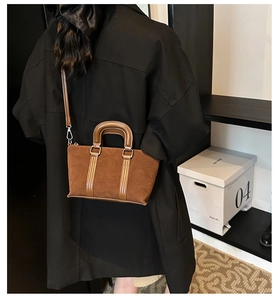 Back view of a model wearing the brown frosted suede satchel bag with caramel leather straps