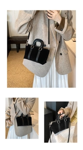 Detail of black suede Boston bag with leather handles and adjustable silver strap