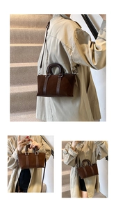 Close-up of matte brown crossbody bag showing suede texture and leather stitching details