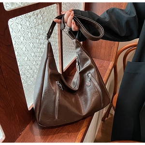 Close-up of vintage dark brown faux leather tote with silver zippers and soft texture