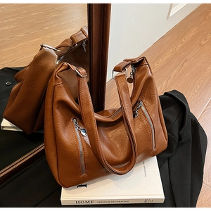 Detail of a brown PU leather tote bag with dual zipper pockets and metallic rings