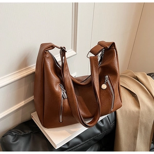 Detailed view of dark brown faux leather tote with pebble texture and silver zippers