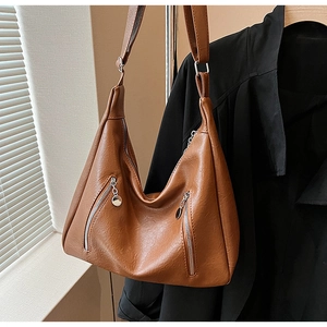 Detail of a brown vintage hobo tote bag featuring double silver zippers and matte texture