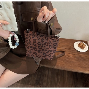 Détail d'un mini sac cabas à imprimé léopard avec texture pelucheuse et bandoulière