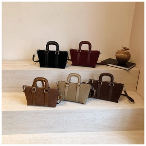 Minimalist matte suede pillow bags in five vintage colors displayed on stone steps