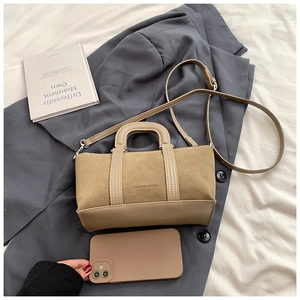 Detail of khaki frosted suede pillow bag with fashion text on grey blazer background