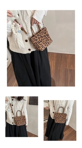 Détail d'un petit sac cabas léopard avec anses en cuir marron et bandoulière fine