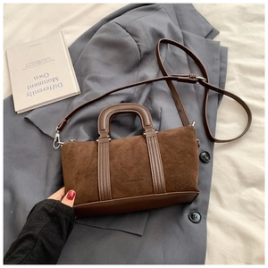 Close-up of matte brown vintage boston bag featuring suede texture and leather handles