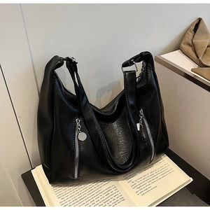 Detail view of black hobo bag with wrinkled faux leather and silver zipper pockets
