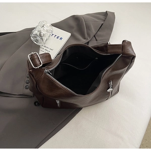 Detail view of large brown chain shoulder bag with spacious interior and silver hardware