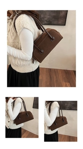 Close-up of retro brown suede Boston handbag with smooth leather handles and texture detail