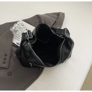 Interior view of black faux leather tote bag showing large capacity and inner pocket detail
