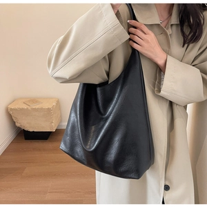 Detail view of large black PU leather tote bag showing soft texture and shoulder strap