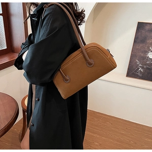 Brown faux suede Boston shoulder bag with slim straps styled on a dark winter coat
