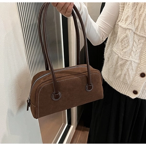 Detail of dark brown suede Boston bag featuring white contrast stitching and fine leather texture