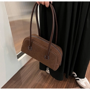 Detailed view of brown suede Boston bag featuring contrast stitching and long shoulder straps