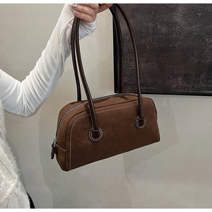 Detailed view of the brown suede Boston bag featuring white contrast stitching and texture