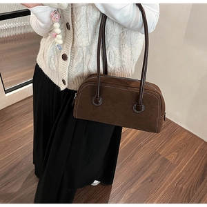 Detail view of brown suede Boston bag with contrast stitching and long shoulder straps