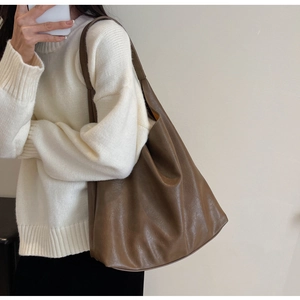 Mirror selfie showing a brown PU leather tote bag with soft draping and long shoulder strap