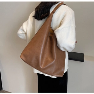 Brown retro PU leather tote bag shown on shoulder to display size and capacity