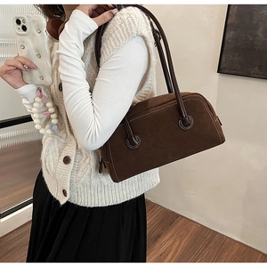 Detail view of brown faux suede Boston bag showing contrast stitching and dual handles