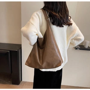 Back view of the large brown PU leather tote bag worn by a model for size perspective