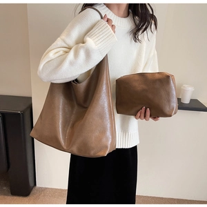 Close-up of brown PU leather tote and clutch set with natural wrinkled texture