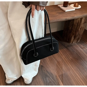 Detail of vintage black faux suede boston bag with white contrast stitching and slim straps