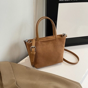 Sac seau minimaliste en daim marron avec poignées et bandoulière réglable pratique