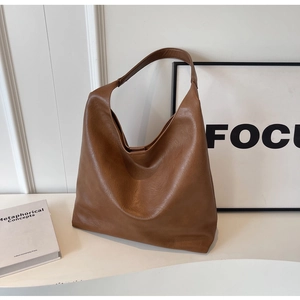 Detail view of large brown matte PU leather hobo bag with wide shoulder strap