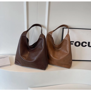 Detail view of brown PU leather hobo tote bags showing smooth texture and minimalist design