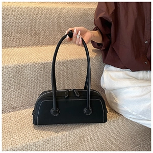 Detail of black tote bag featuring white contrast stitching and dual zipper closures