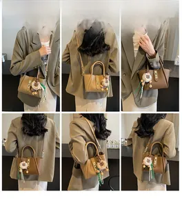 Litchi pattern brown bucket bag with lion charm shown in shoulder and crossbody modes