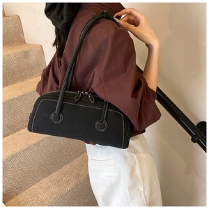 Detail of black tote bag with white contrast stitching and double zipper closure