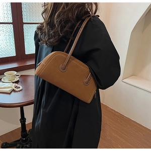 Detail of brown vintage suede Boston bag with white stitching and leather texture