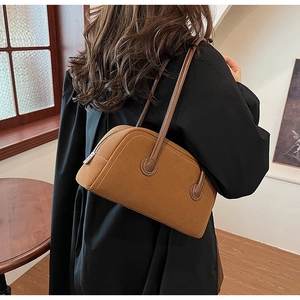 Brown faux suede Boston bag with contrast stitching shown styled on a black winter coat