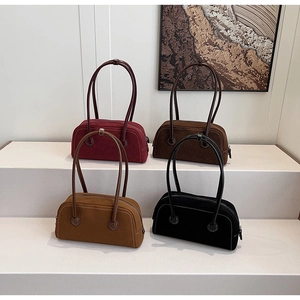 Detailed view of suede Boston bags in burgundy, coffee, khaki, and black with contrast stitching