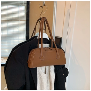Detail of vintage brown leather tote bag featuring white contrast stitching and dual handles