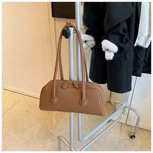 Detail of caramel leather boston bag with white contrast stitching and dual zippers