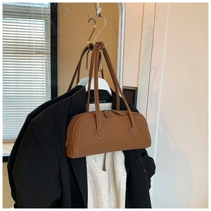 Detailed view of brown leather Boston tote bag with decorative white contrast stitching