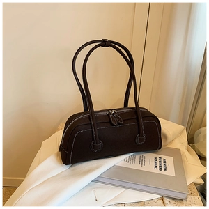 Detailed view of dark brown tote bag with contrast white stitching and dual zippers