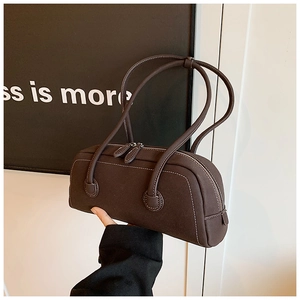 Detail of dark brown leather tote with white stitching and dual zipper closures