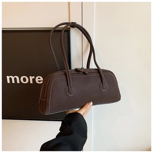 Detail of dark brown suede tote bag featuring white contrast stitching and dual handles