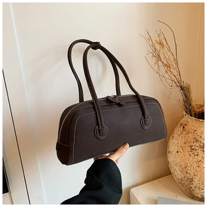 Detail of dark brown tote bag with white contrast stitching and double zipper design