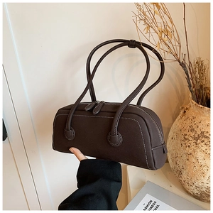 Detailed view of the dark brown leather tote bag with white contrast stitching details
