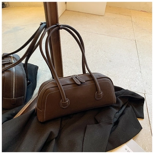 Detail of a dark brown rectangular tote bag with contrast stitching and dual zippers