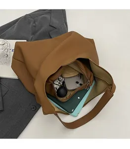 Detail of spacious brown tote bag interior with inner pouch and daily essentials